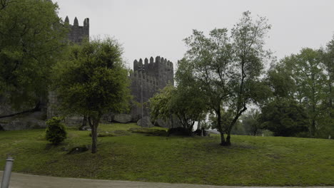 Raindrops-fall-across-grassy-lawn-grounds-of-old-castle-on-overcast-day