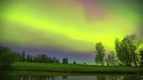Aurora-borealis-or-northern-lights-over-a-countryside-landscape---time-lapse