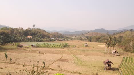 looking-down-on-bright-green-rice-terraced-fields-in-the-mountain-town-of-Nong-Khiaw-in-Laos,-Southeast-Asia