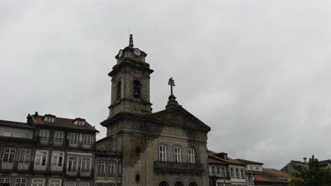 Static-shot-of-rainy-wet-water-spread-across-old-historic-stone-clock-tower-building