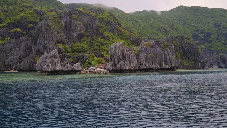 Exotic-Tropical-Beach-Between-Limestone-Cliffs-and-Rocks-in-Sea,-Amazing-Scenery-of-El-Nido,-Palawan-Islands,-Philippines