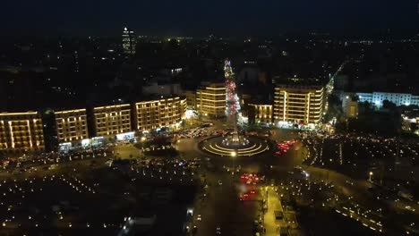 Aerial-of-Tahrir-square,-meanders-through-Cairo-city-at-night,-with-a-drone-gliding-past-the-beauty-of-Cairo,-Egypt,-embodying-the-concept-of-urban-vitality-and-architectural-marvels