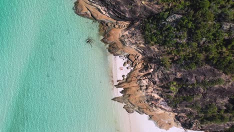 A-4k-drone-view-looking-down-at-a-couple-laying-on-Whitehaven-Beach-on-Whitsundays-Island