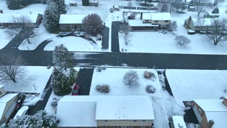 Vista-Invernal-De-Un-Barrio-Suburbano-Con-Casas,-Patios-Y-Carreteras-Cubiertos-De-Nieve,-Bajo-Un-Cielo-Gris