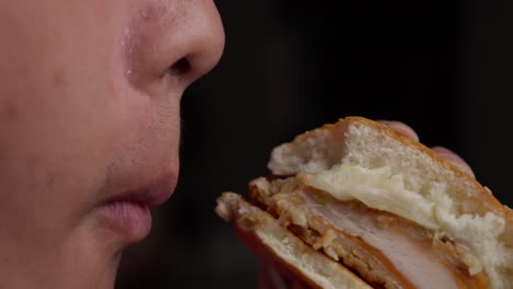 Man-biting-into-half-chicken-burger