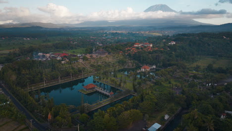 Sunrise-drone-view-over-touristic-Ujung-Floating-Palace-in-lush-Bali-countryside