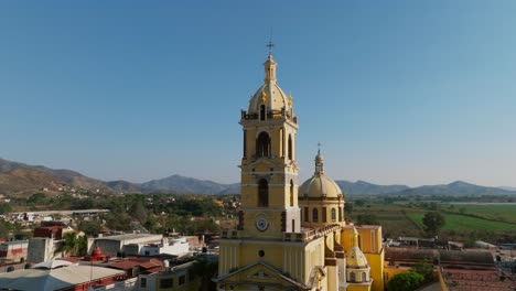 Establishing-aerial-of-the-Santuario-Diosesano-catholic-church-facade-in-Tamazula-de-Gordiano,-dolly-in-tilt-up