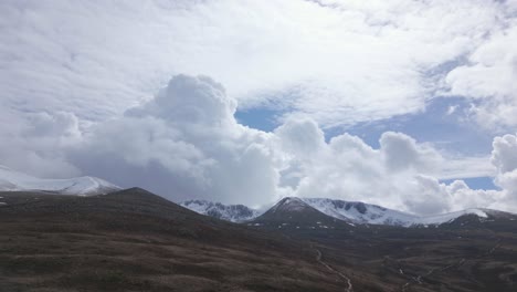 Clouds-touching-tops-of-snow-covered-mountains,-Cairngorms,-Scotland