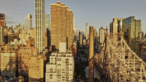 NYC-New-York-Aerial-v380-tracking-flyover-East-River-from-Sutton-Place-to-Lenox-Hill-capturing-Queensboro-Bridge-and-skyscrapers-cityscape-at-sunrise---Shot-with-Mavic-3-Pro-Cine---September-2023