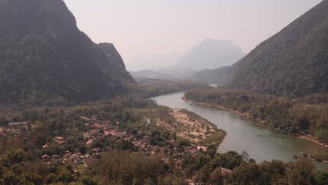 Río-Que-Fluye-A-Través-Del-Valle-En-La-Ciudad-Montañosa-De-Nong-Khiaw-En-Laos,-Sudeste-De-Asia