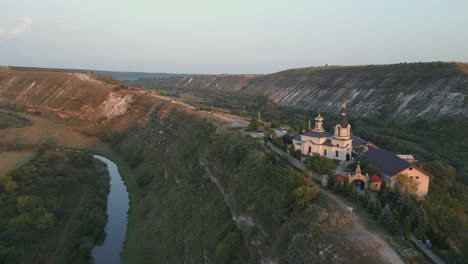 Seitlicher-LKW-Drohnenschuss-über-Einem-System-Historischer-Monumente-Und-Natürlicher-Landschaften-Des-Alten-Orhei-Klosters-Und-Alter-Höhlen-Bei-Sonnenuntergang