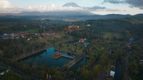 Palacio-Turístico-Del-Agua-Taman-Ujung-Con-El-Monte-Agung-Al-Fondo,-Vista-Aérea