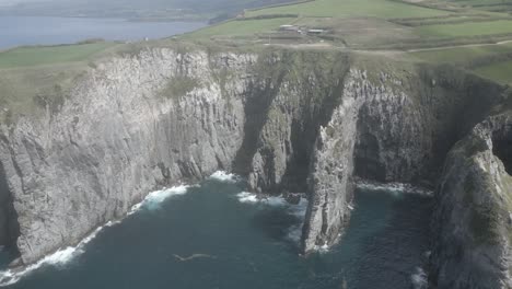 Aerial-panoramic-view-of-Ponta-do-Cintrao-cliffs-from-Miradouro-da-Ribeirinha-viewpoint,-Sao-Miguel-Island,-Azores,-Portugal