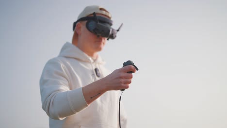 Unmanned-aircraft-pilot-use-goggles-and-rc-motion-remote-to-fly-FPV-drone