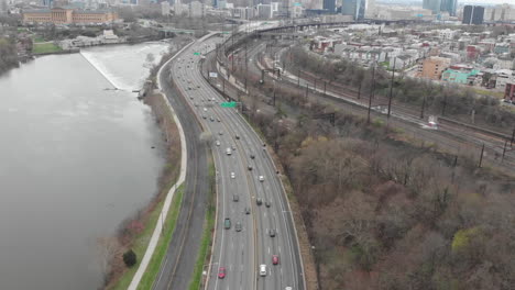 Cars-Traffic-flows-through-the-street-against-the-backdrop-of-the-cloudy-Philadelphia-skyline