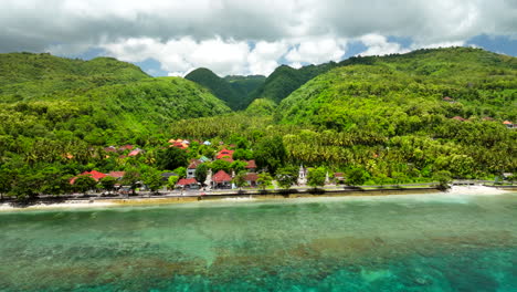 Colors-contrast-between-green-forest-and-turquoise-sea-waters,-Nusa-Penida-island,-Bali-in-Indonesia