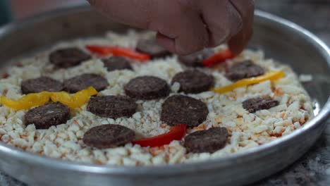 A-chief-puts-peppers-on-an-Italian-pizza,-close-up-shot,-insert-shot