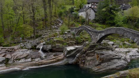 Ponte-dei-Salti-bridge-with-two-arches-looks-over-green-stream-water-in-Switzerland