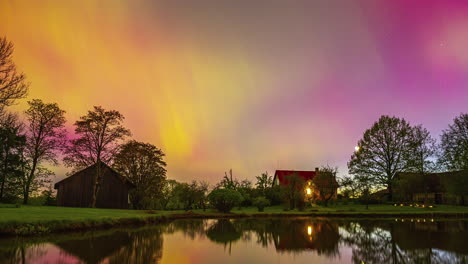 Aurora-borealis-over-a-countryside-farm-and-pond---nighttime-time-lapse