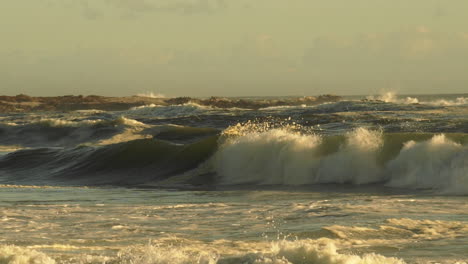 Olas-Del-Mar-Agitadas-Que-Crean-Rocío-Y-Espuma-Durante-La-Tarde-Dorada---Plano-Medio