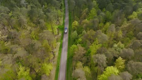 Caravana-Airstream-En-Una-Carretera-En-Medio-De-Un-Bosque.