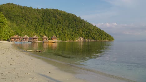 Luxury-wooden-huts-along-exotic-beach-of-Kri-island-in-Raja-Ampat-archipelago,-West-Papua-in-Indonesia