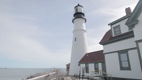 Beautiful-up-close-view-of-the-Portland-Maine-Head-Light-light-house-during-a-beautiful-spring-day-with-waves-rolling-into-the-rocky-shore-in-4k
