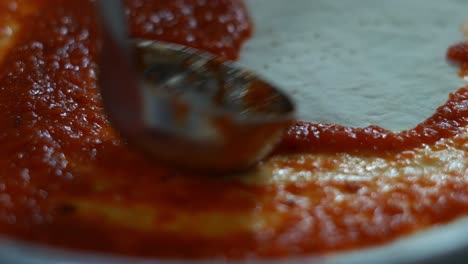 Un-Jefe-Agrega-Salsa-De-Tomate-A-Una-Pizza-Italiana,-Toma-De-Primer-Plano,-Inserta-Toma