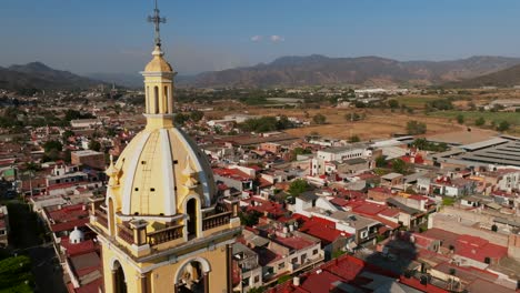 Aerial-dolly-flight-extremely-close-to-the-church-bell-tower-in-Tamazula-de-Gordiano-city-center