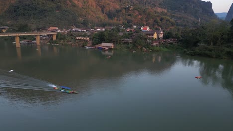 Toma-De-Drone-De-Un-Barco-En-El-Río-En-La-Ciudad-Montañosa-De-Nong-Khiaw-En-Laos,-Sudeste-Asiático