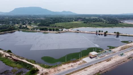 Vista-Aérea-De-Un-Enorme-Panel-Solar-Sobre-El-Agua-En-Una-Zona-Rural,-Granja-Solar-Flotante