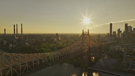 NYC-New-York-Aerial-v382-drone-flyover-Queensboro-bridge-over-East-river-capturing-Long-Island-City-cityscape-at-sunrise-with-glowing-sun-in-the-sky---Shot-with-Mavic-3-Pro-Cine---September-2023