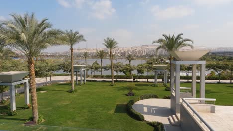 Lush-green-lawn-with-date-palm-trees-and-white-shade-awnings-looking-across-Nile-River