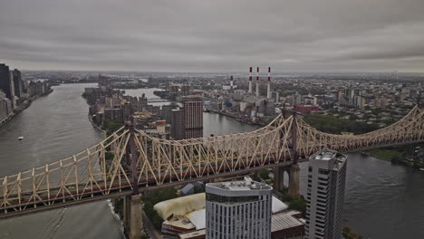 NYC-New-York-Aerial-v457-flyover-Queensboro-bridge-over-East-river-and-Roosevelt-Island-capturing-Long-Island-City's-skyline-with-storm-clouds-overhead---Shot-with-Mavic-3-Pro-Cine---September-2023