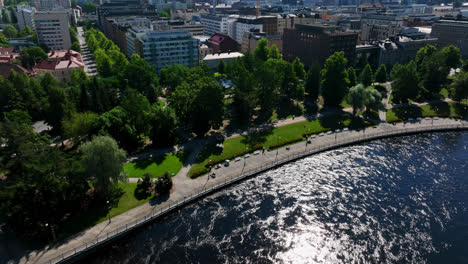AERIAL:-Tammerkoski-river-and-the-Koskipuisto-park,-in-sunny-Tampere,-Finland
