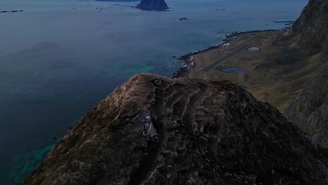 Hombre-Corriendo-En-La-Cima-De-Una-Colina-Rocosa-Hacia-El-Borde-Junto-Al-Mar