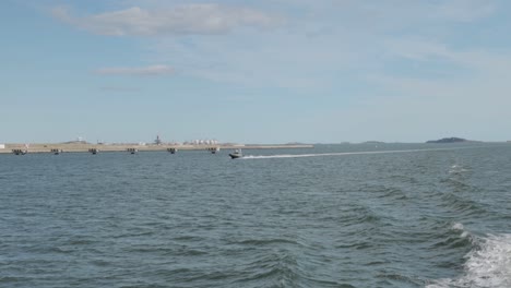 Boston-Harbour-view-of-the-city-scape-from-a-ferry-with-a-motor-boat-cruising-along-side