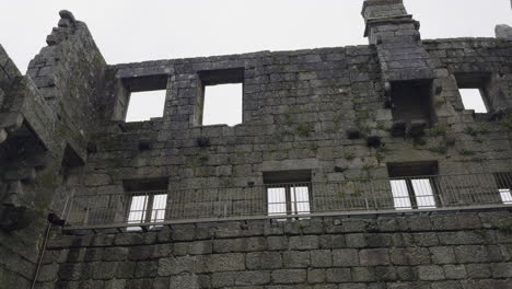 Panorámica-Ascendente-A-Través-De-Decrépitos-Muros-De-Castillo-De-Ladrillos-Rotos-Con-Valla-En-Días-Lluviosos