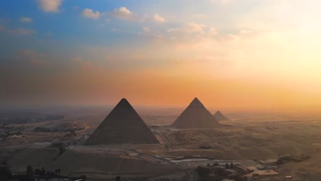 Luftaufnahme-Des-Sonnenuntergangs-über-Den-Großen-Pyramiden-Von-Gizeh-Auf-Dem-Pyramidenplateau-In-Ägypten-Verkörpert-Das-Konzept-Zeitloser-Erhabenheit-Und-Majestät