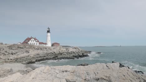 Beautiful-rocky-sea-side-view-of-the-Portland-Maine-Head-Light-light-house-during-a-beautiful-spring-day-with-waves-rolling-into-the-rocky-shore-in-4k