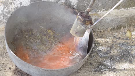 Utilice-Una-Cocina-De-Gas-Portátil-Con-Quemador-Para-Derretir-Plomo-En-Una-Olla-De-Hierro-Fundido,-Chispas-Y-Fuego-De-Cerca