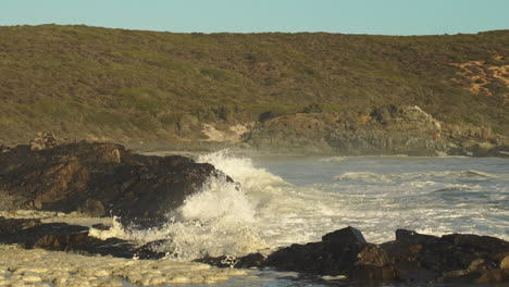 Olas-Del-Mar-Agitadas-Rompiendo-En-La-Costa-Rocosa-Creando-Un-Enorme-Rocío---Toma-Estática-Amplia