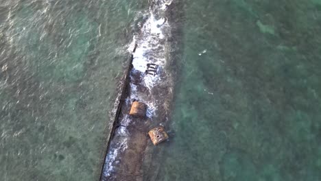 Drone-aerial-spinning-over-shipwreck-in-the-ocean-during-sunset