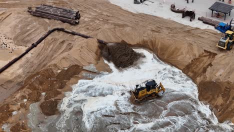 Ein-Bulldozer-Bewegt-Sand-Und-Wasser-Auf-Einer-Großen-Baustelle