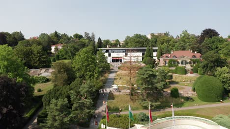 Drone-slowly-flies-towards-the-Olympic-Museum-in-Lausanne,-Switzerland