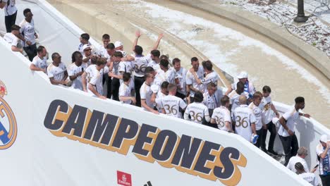 Real-Madrid-players-gather-at-Cibeles-Square-in-Madrid,-Spain,-to-celebrate-their-36th-La-Liga-championship-next-to-the-word-'Champions'-