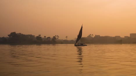 Aerial-of-the-Nile-River-sunset,-traditional-Egyptian-sailing-boats,-in-Aswan,-Egypt,-embodying-the-concept-of-timeless-maritime-heritage-and-cultural-richness