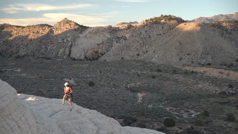 Young-Woman-on-Hiking,-Walking-Alone-on-Top-of-Sandstone-Hill-at-Sunset,-Slow-Motion