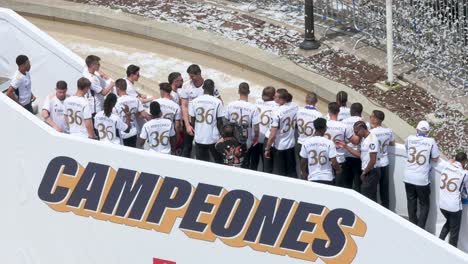 At-Cibeles-Square-in-Madrid,-Spain,-Real-Madrid-players-celebrate-their-36th-La-Liga-title-next-to-the-word-'Champions'-