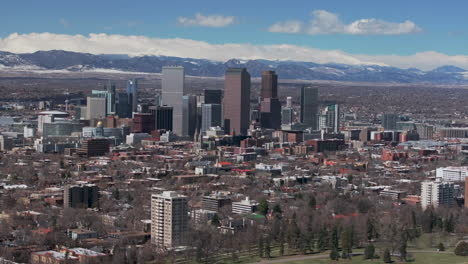 Denver-Colorado-City-Park-Flat-Irons-Boulder-Aerial-drone-USA-Front-Range-Mountain-foothills-landscape-of-downtown-skyscrapers-Wash-Park-Ferril-Lake-daytime-sunny-clouds-neighborhood-backward-motion